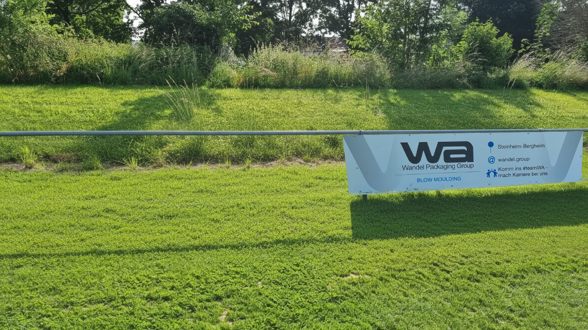 Sponsoring Bande der Firma WA vor grünem Rasenhintergrund